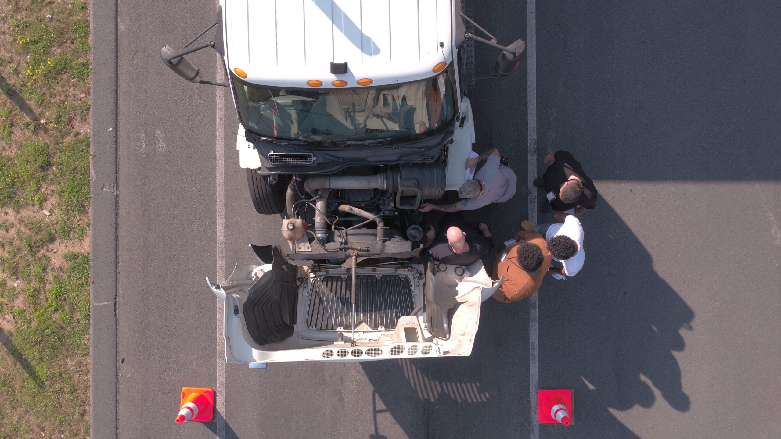 Students working on a semi with the hood up
