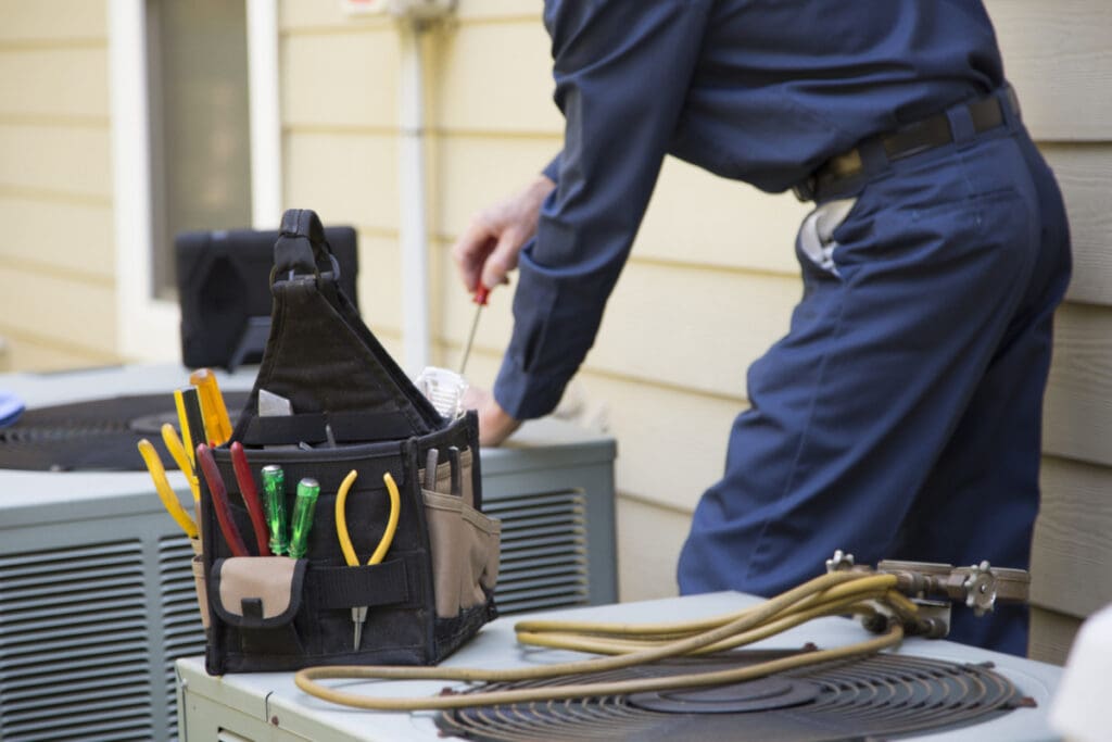 An HVAC tech working on an AC unit